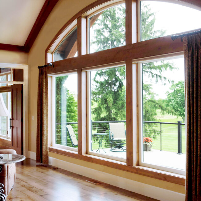 Inside view of large windows, combination of arch windows and picture windows; example of Aeris windows in article about wood vs vinyl windows