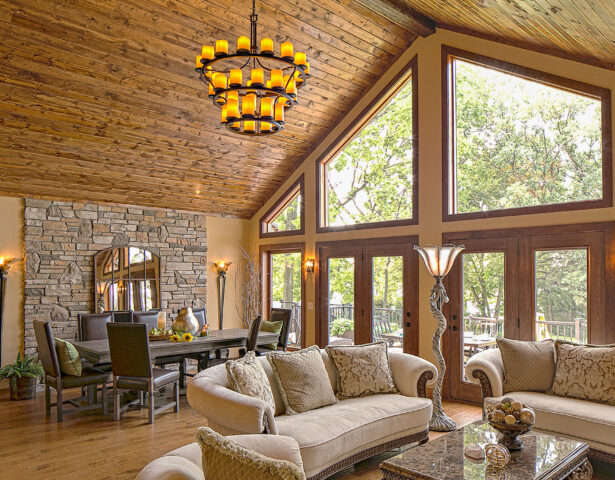 Trapezoid shaped wood clad architectural windows inside a rustic living room; example of shaped windows in ProVia's window gallery