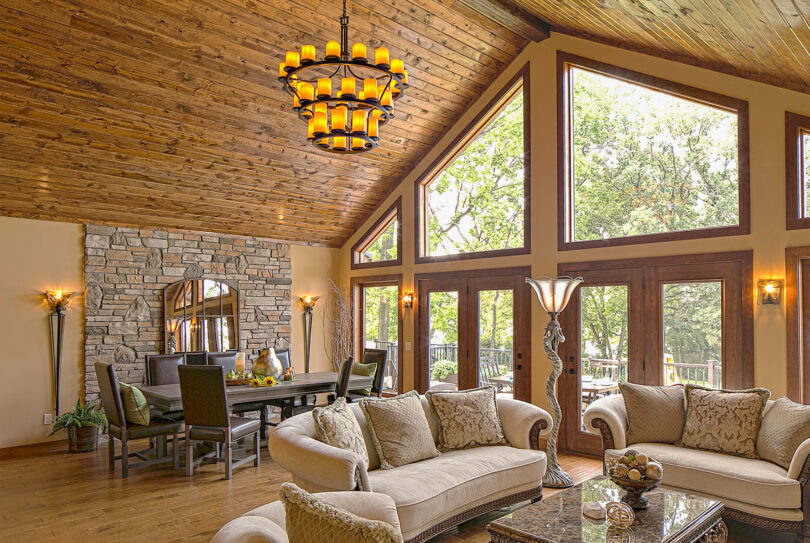 Trapezoid shaped wood clad architectural windows inside a rustic living room; example of shaped windows in ProVia's window gallery