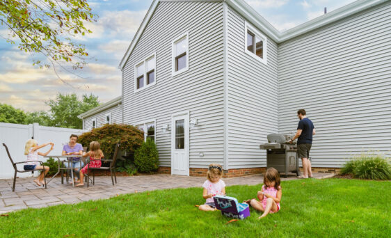 House with ProVia vinyl siding and family having fun in the yard