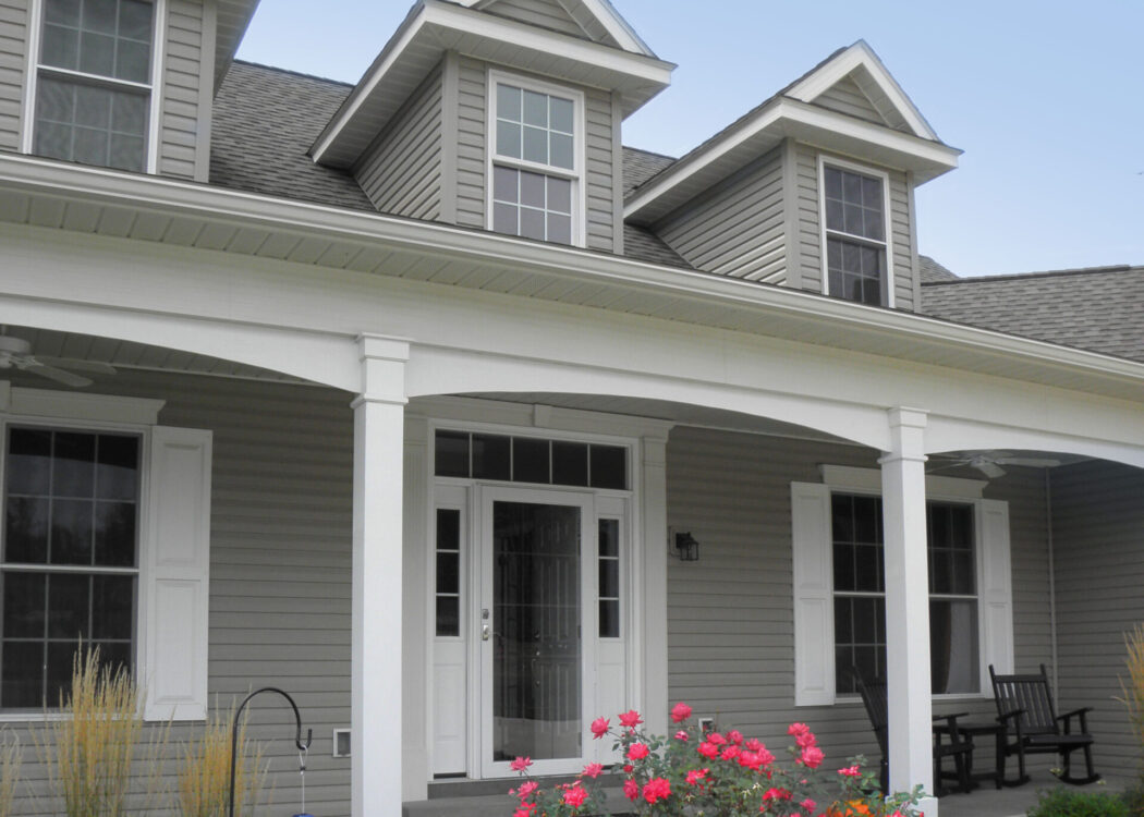 Ultra vinyl lap siding in the color Gray, example of a Cape Cod style home with Cape Cod style front door and windows.