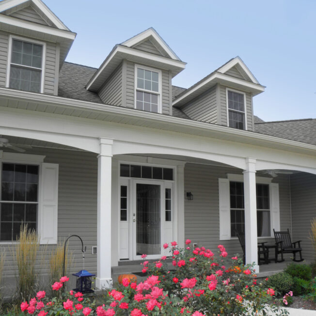 Ultra vinyl lap siding in the color Gray, example of a Cape Cod style home with Cape Cod style front door and windows.