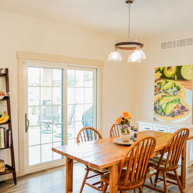 Interior view of a ProVia Endure™ sliding glass patio door in White with Colonial Grids in a dining room