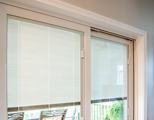 Closeup image of white blinds in sliding glass doors, which are ProVia Endure vinyl sliding glass patio doors