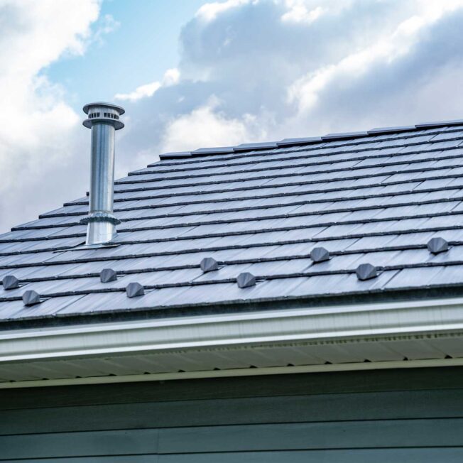 Closeup of a home with ProVia's gray Pepperwood Shake metal shingle roof that resembles the look of shake shingles