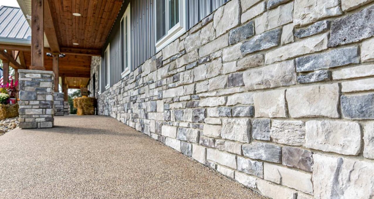 Terra Cut Frost manufactured stone veneer on the bottom portion of a home's exterior, example of stone colors that combine grays, whites, browns, and a hint of reds