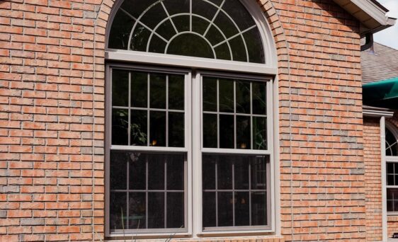 Aeris double hung and shaped windows with grids in the color Sandstone