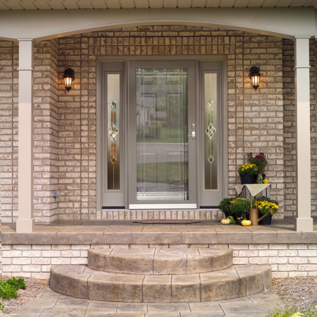 Decorator Full View glass decorative storm door in Sandstone on a front porch with columns