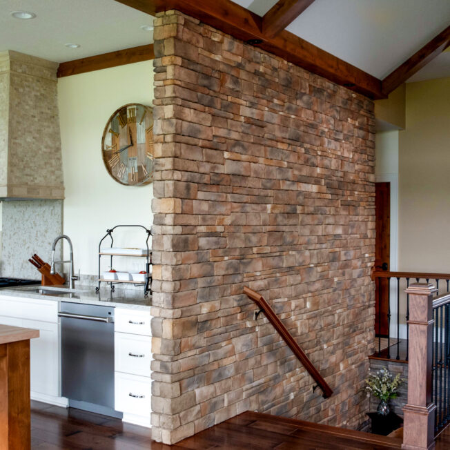 Photo of a feature stone interior wall with ProVia's Dry Stack stone in the color Colorado, which includes a mix of brown, red, and gray stone