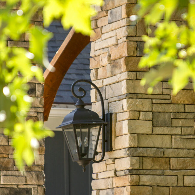 Closeup of a home exterior with dry stack stone veneer in a color called Seneca, home exterior color ideas for brown stacked stone