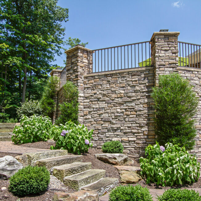 Photo of an outdoor stone veneer application on a patio area that features ProVia's dry stack stone veneer in the color Seneca, which includes shades of brown stone