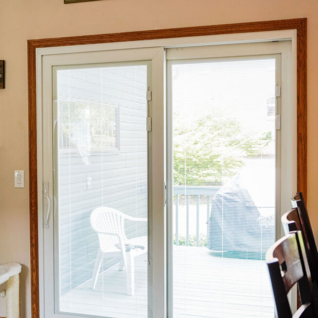 Interior view of a ProVia Endure™ Patio Door in White with White Internal Blinds in a dining room