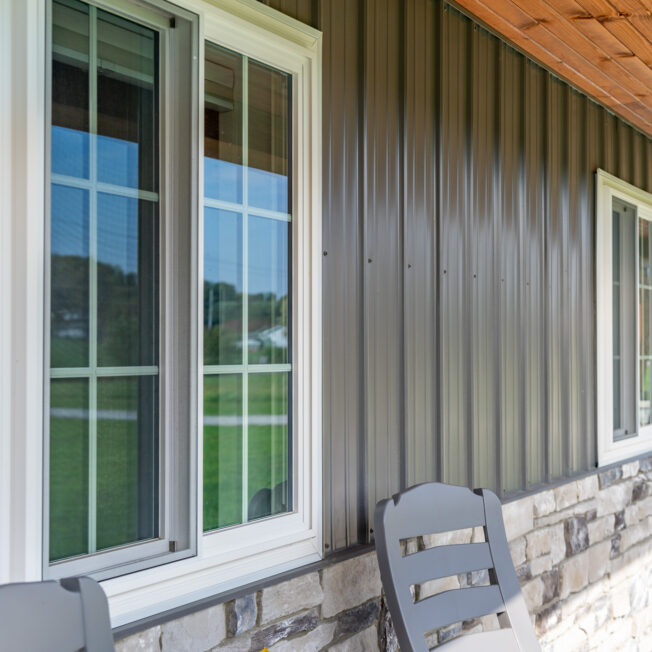 Outside view of white sliding windows with cottage-style grids