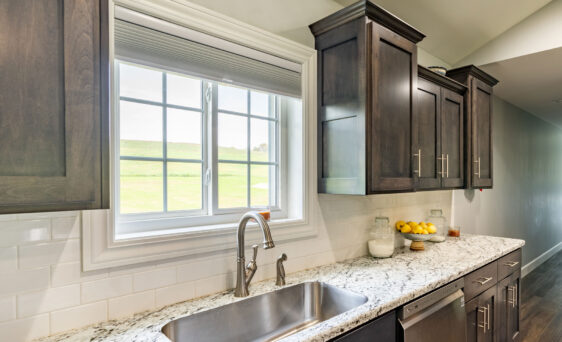 White sliding windows with cottage-style grids in a kitchen above the sink; example of slider pictures of windows in ProVia's window gallery