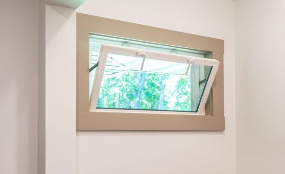 An opened Sandstone colored hopper window in a laundry room