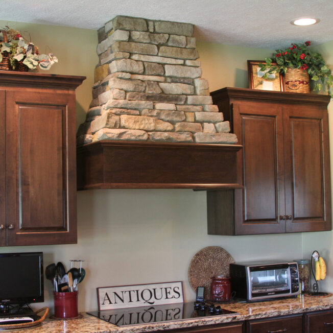 Osage Ledgestone accents in a kitchen on a range vent hood. Manufactured stone is among one of the top value added home improvements.