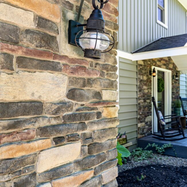 Closeup view of Ledgestone veneer in the color Saginaw, which includes a blend of browns, grays, and reds on a home exterior