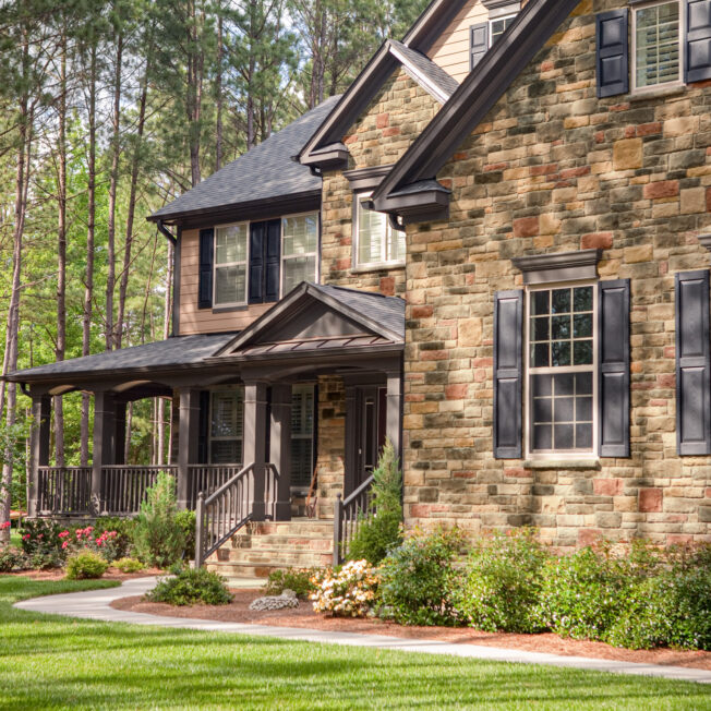 ProVia Limestone manufactured stone veneer in the color Allegheny on the exterior of a two-story home