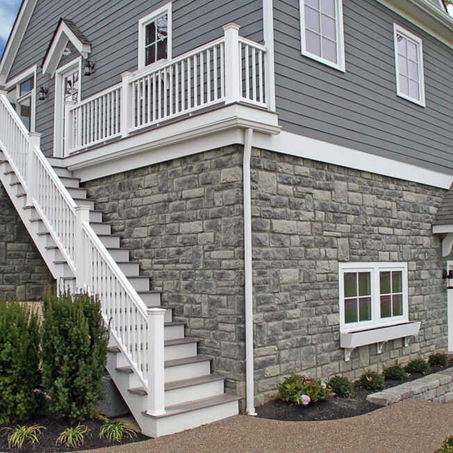 ProVia Limestone Blue Ridge manufactured stone on the exterior bottom half of a home with a walkout basement