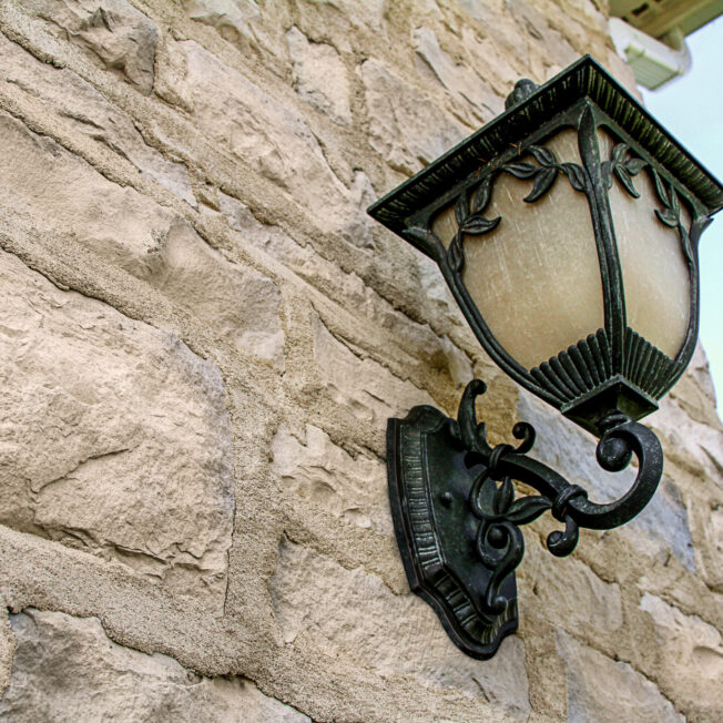 Exterior stone veneer with antique exterior light fixture showing stone grout technique