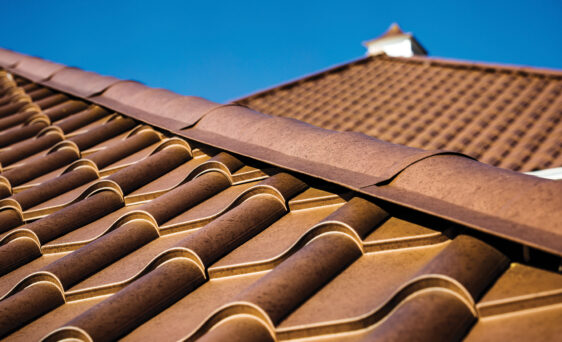 Closeup image of ProVia Metal Barrel Tile Roofing in Terracotta installed on a home