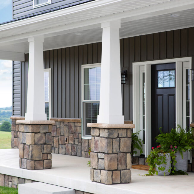 View of ProVia's Natural Cut manufactured stone veneer in Ashworth, example of how ProVia stone can be combined with stone veneer accessories and applied to porch columns and on the exterior of a home