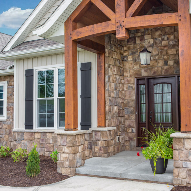 ProVia Natural Cut™ Woodbridge Manufactured Stone on the exterior of a craftsman-style home paired with siding and timber framing