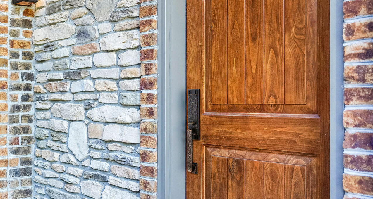 Closeup of a Signet® 002CP 449 entry door in Caramel stain with a painted entry door frame