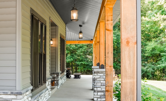 Vinyl Soffit in Coal Black on the porch of a home with manufactured stone, vinyl siding, and timber frames