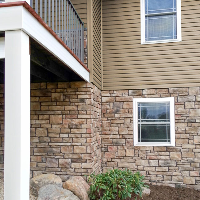 ProVia Terra Cut manufactured stone on the lower level of a home in the color Russet, example of how exterior stone for houses can be used