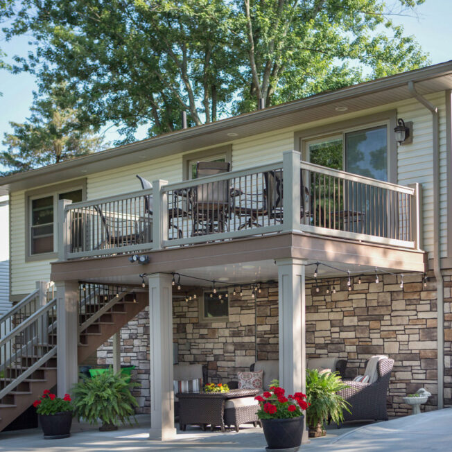 Image showing the back of a home with a walkout basement displaying ProVia Terra Cut™ manufactured stone in the color Summit