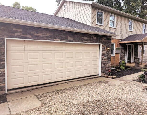 Two-story home with older, cream-colored siding before the home received new ProVia vinyl siding