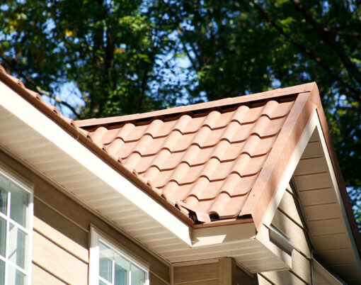 Closeup view of a home with ProVia's new metal barrel tile roof in Terracotta, example of metal roofing that looks like clay tile