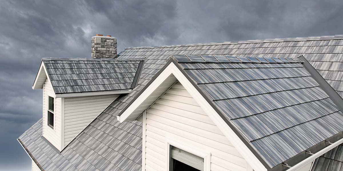 Closeup image of a stormy sky and ProVia Pepperwood Shake metal house roofing system