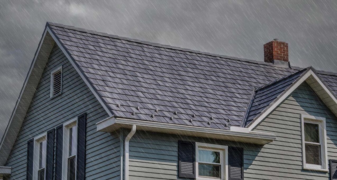 Photo of a house in the rain showing a detailed ProVia Baystone Slate metal durable roofing system