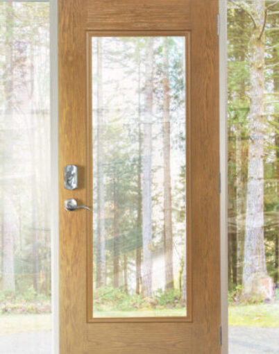 A ProVia Signet® Oak Door with Clear Glass Sidelites looking out at a view of trees outside
