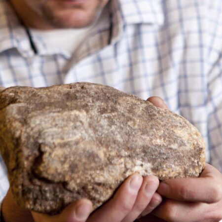 Man holding a stone that represents the concept of ProVia manufactured stone artisanship
