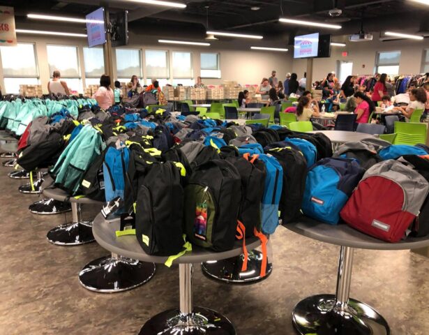 Free backpacks stuffed with school supplies line the lunchroom at ProVia at annual Prepare for Success event