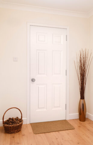 Inside view of a white Legacy™ 006 steel entry door in an apartment