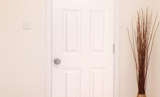 Inside view of a white Legacy™ 006 steel entry door in an apartment