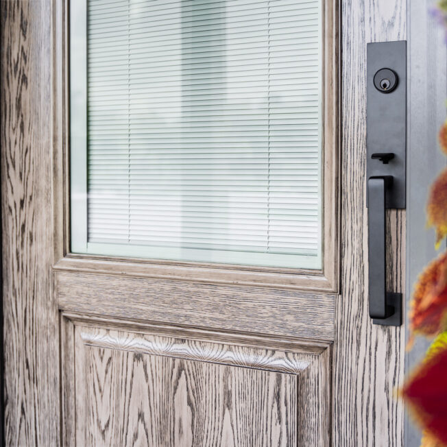 Closeup view of a ProVia Signet® 430 entry door in Windy City Glaze with White Internal Blinds