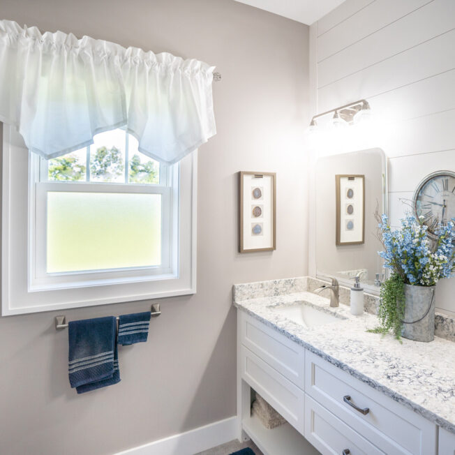 Inside view of a white bathroom with a ProVia Endure™ Double Hung Windows in White with Obscure Pebble Privacy Glass