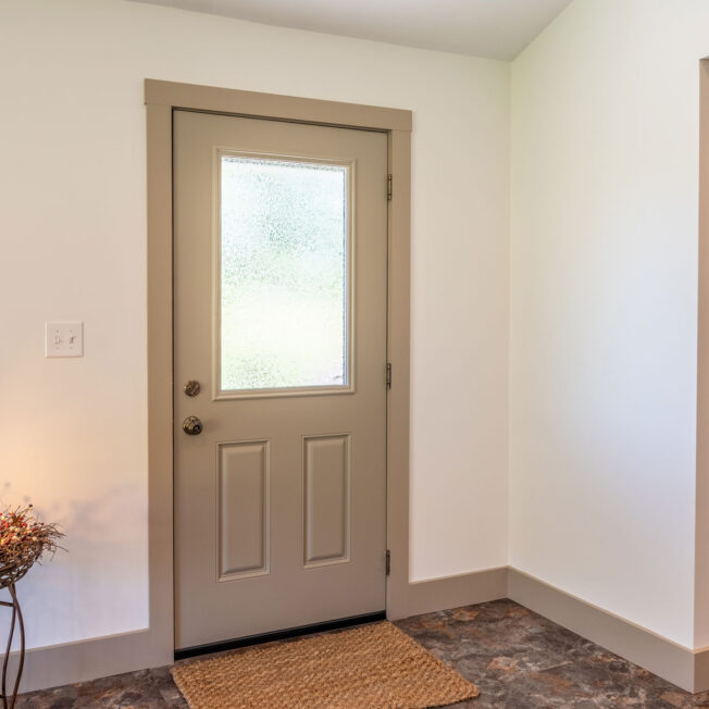 Inside view of a Heritage smooth fiberglass entry door in Sandstone beige with Gluechip privacy glass