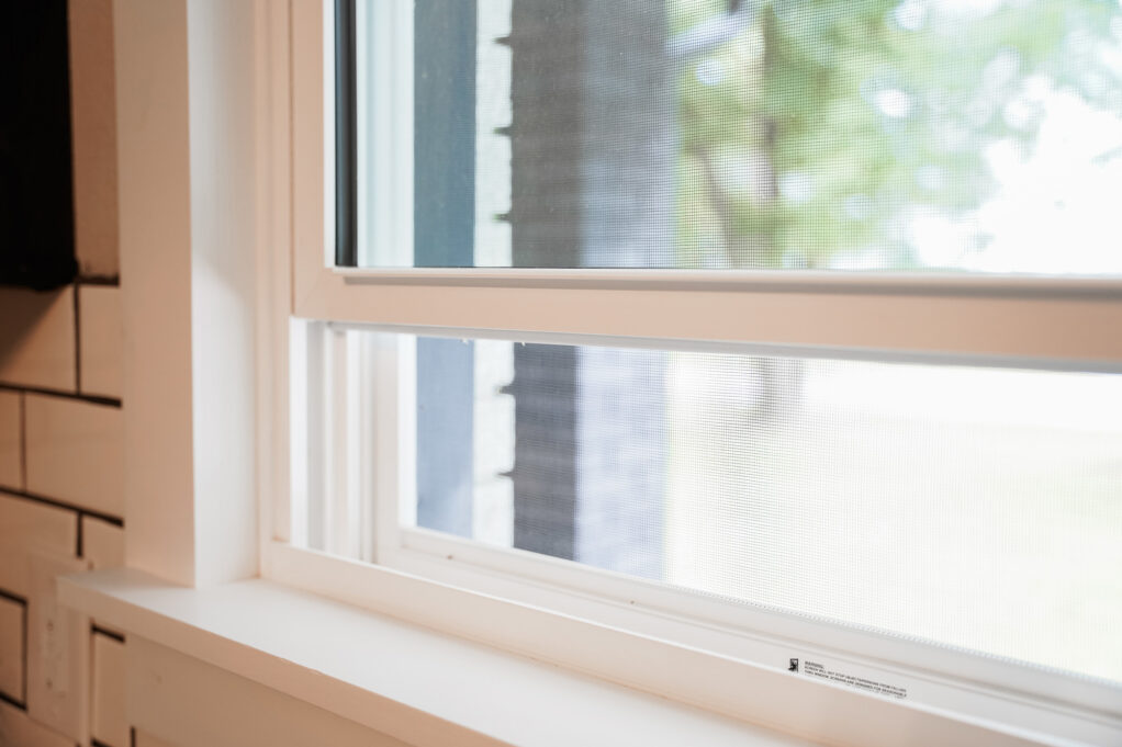 Closeup view of an open ProVia vinyl window showing the built in window screen