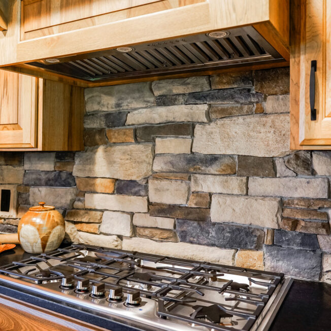 Warm interior image of ProVia Ledgestone Brighton with Fieldstone Strathmore Manufactured Stone in kitchen