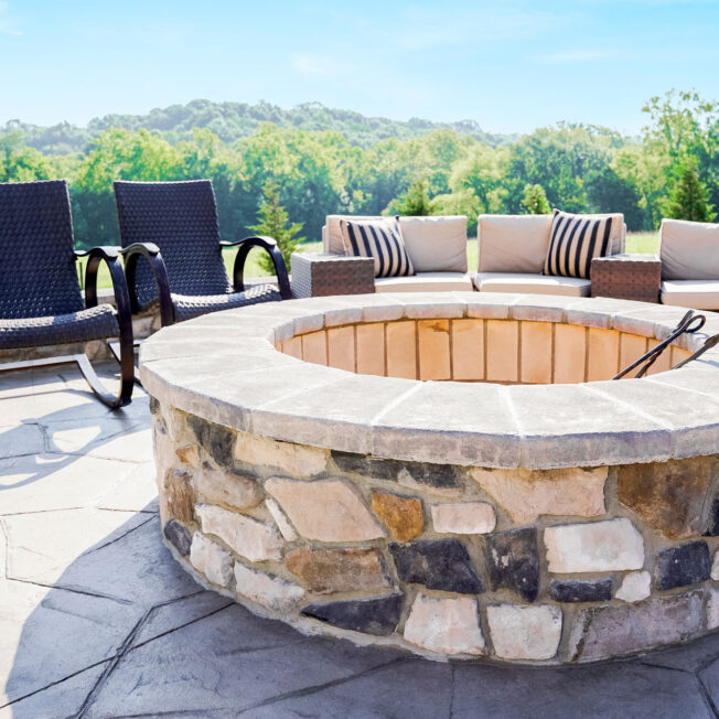 Scenic outdoor image of a ProVia Ridge Cut Denali™ manufactured stone firepit