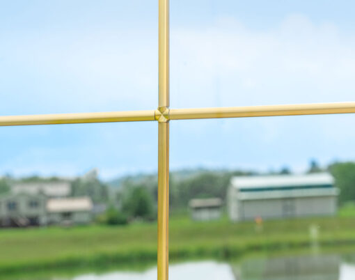 Closeup view of pencil entry door grid option in the color Brass