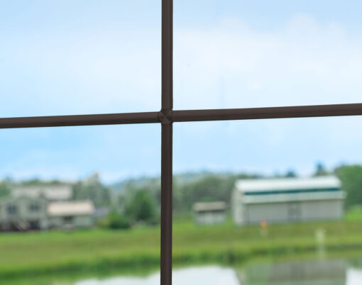 Closeup view of pencil entry door grid option in the color Bronze