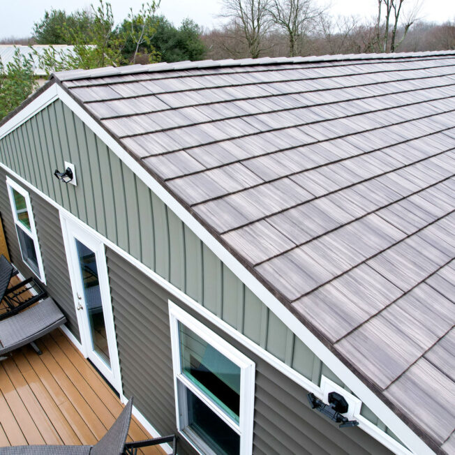 {Aerial photo of ProVia shake metal roofing in a light gray color called Pepperwood}