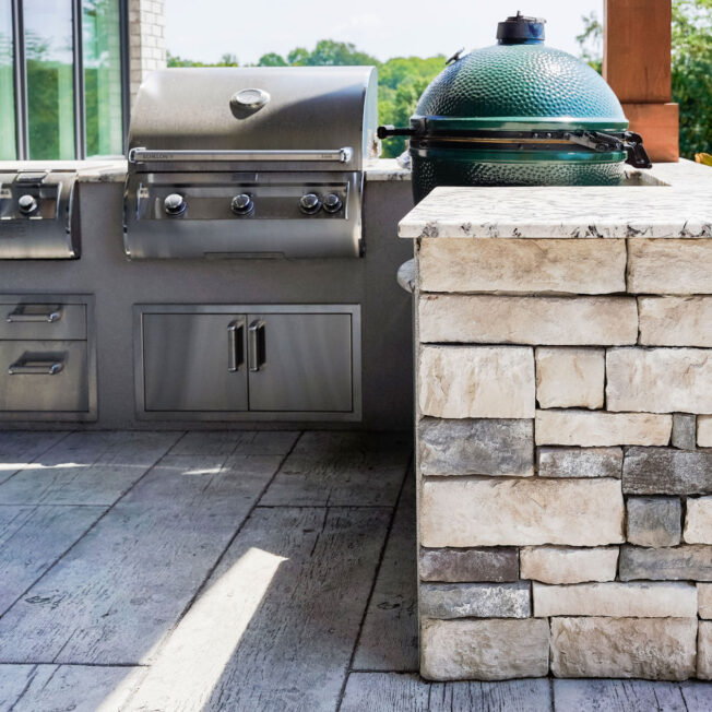 {Outdoor kitchen grill area featuring ProVia's Terra Cut manufactured stone in the color Frost in ProVia's stone gallery}